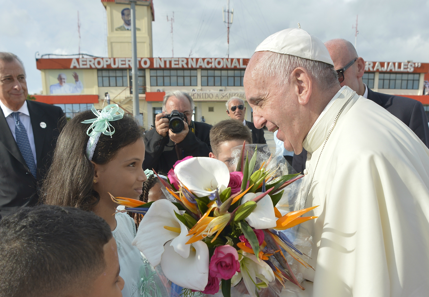 Pope Francis receives flowers at his arrival at the International Airport of Santiago de Cuba