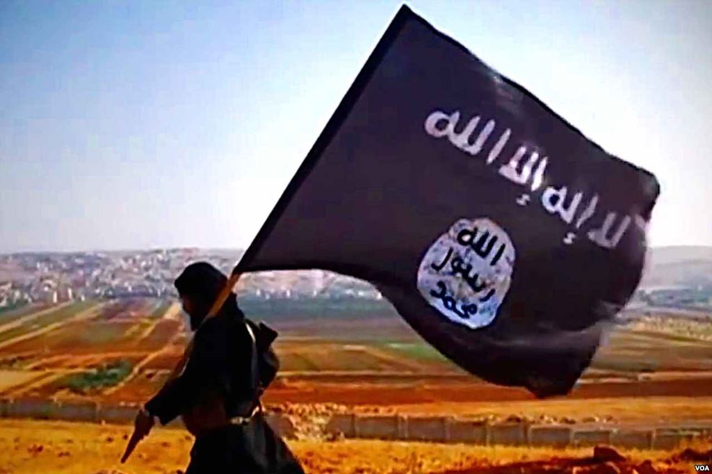 A member of the organization with the flag of the Islamic State