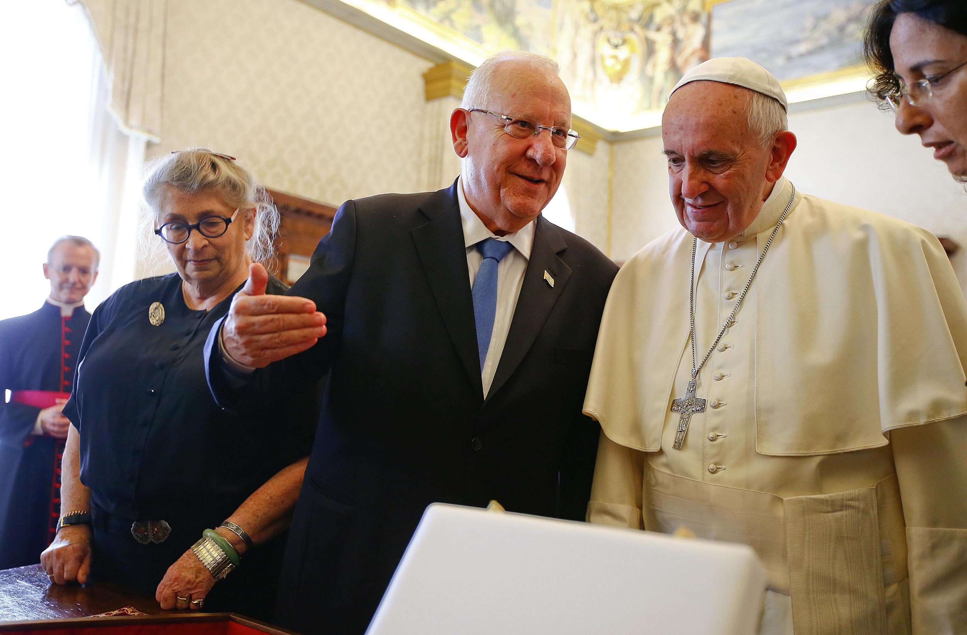 Pope Francis listens to Israel's President Reuven Rivlin as they exchange gifts during a private audience in the Pontiff's private library at the Vatican
